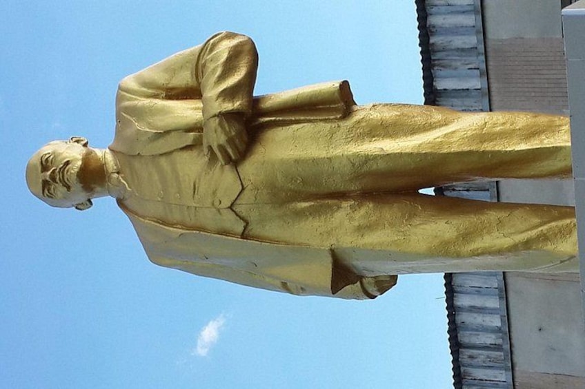 Een groot gouden standbeeld van een man, buiten geplaatst. 2