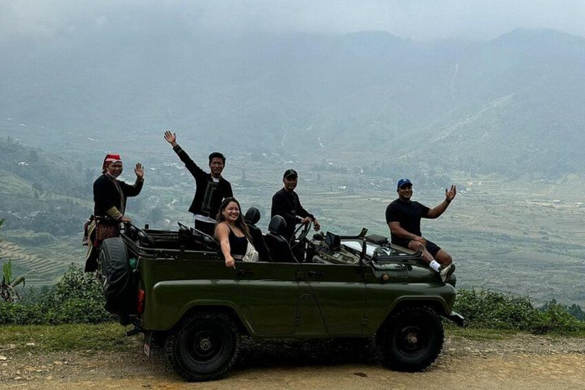 A group of people on a green jeep in a mountainous area. 5