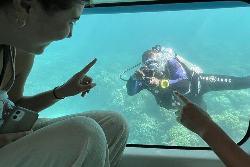 A person in a blue wetsuit with 'WAVES LUNG' on the side, pointing at a diver in a purple wetsuit. 1