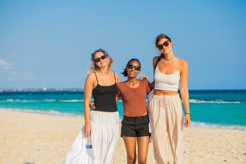 Three people standing on a beach with the ocean in the background. 2