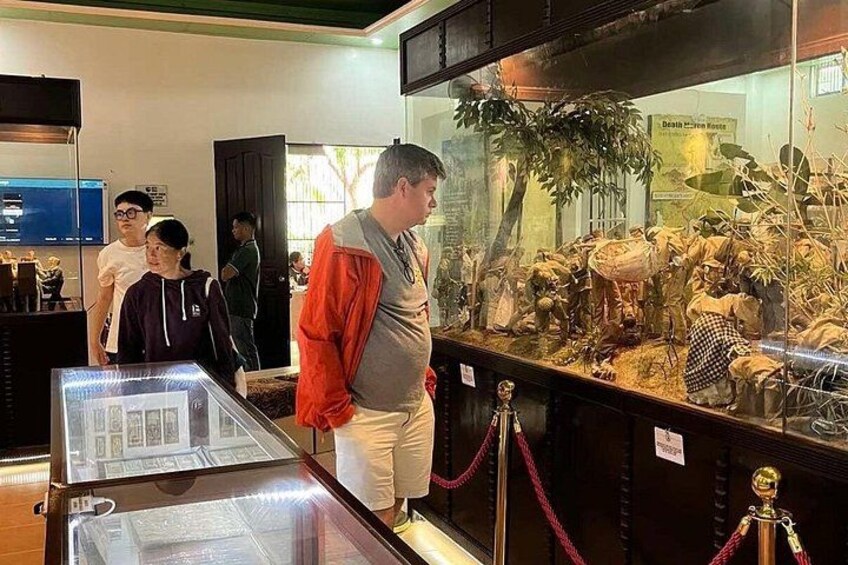 A museum exhibit with glass display cases containing artifacts and models. 4