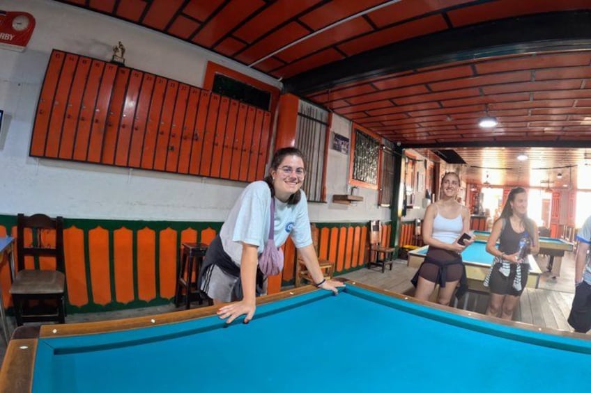 A pool table in a room with orange lockers and a wooden ceiling. 4