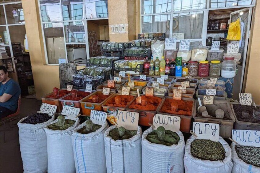 A market stall with various dried herbs and spices displayed in sacks and containers. 3