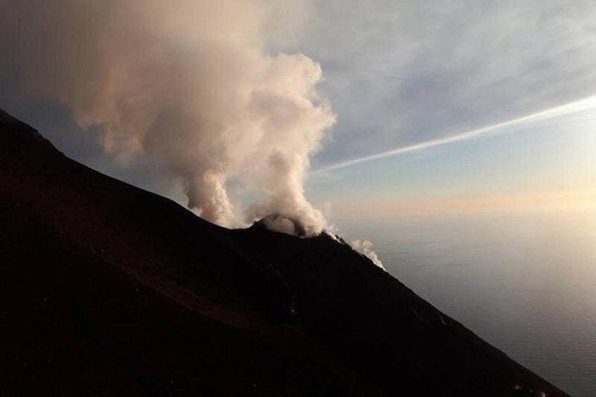 A mountain with a plume of smoke or steam rising from its peak. 5
