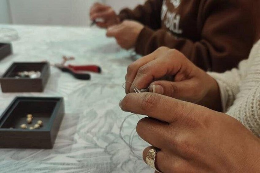 Une personne tenant un petit objet, peut-être un bijou, et portant une bague à un doigt. 2