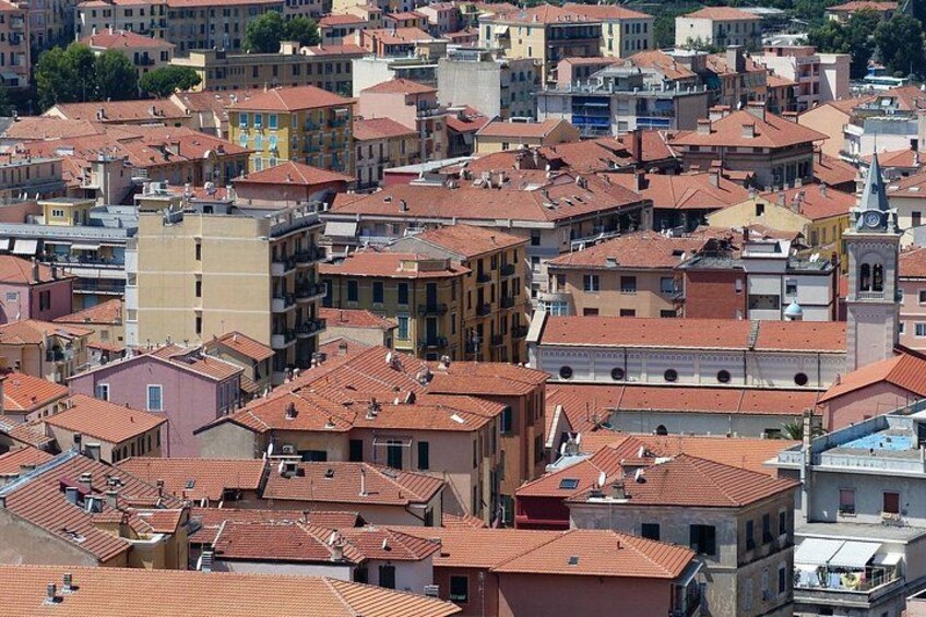 A densely packed urban area with numerous buildings, some with red-tiled roofs, and a prominent clock tower. 5