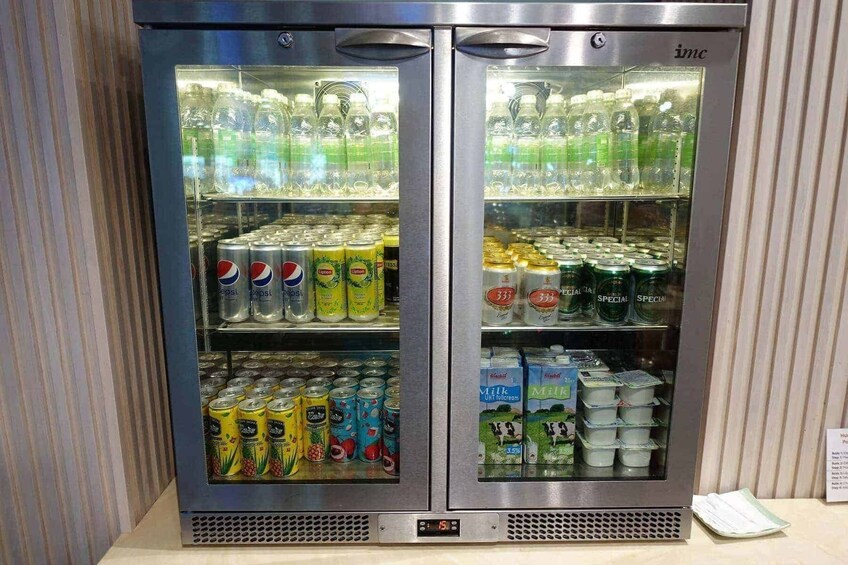 A beverage refrigerator stocked with various drinks including Pepsi, Lipton tea, and milk. 3