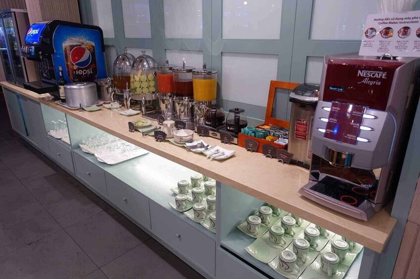 A coffee station with a Nescafé machine, various drink dispensers, and neatly arranged cups and saucers. 4