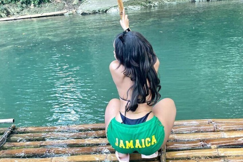 Una persona seduta su una zattera di bambù in un fiume. 1