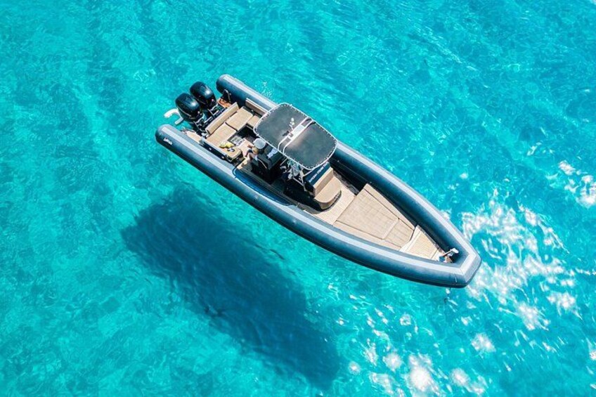 Un petit bateau gonflable à la dérive sur une eau d’un bleu limpide. 1