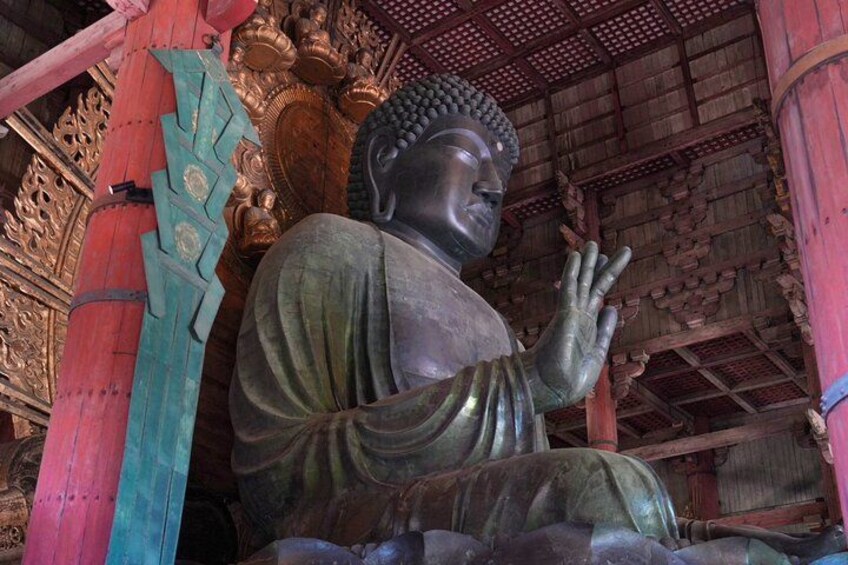 Un'imponente statua di Buddha seduto in un contesto templare tradizionale. 3