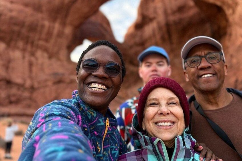 Un grupo de personas en un paisaje natural con formaciones rocosas rojas. 3
