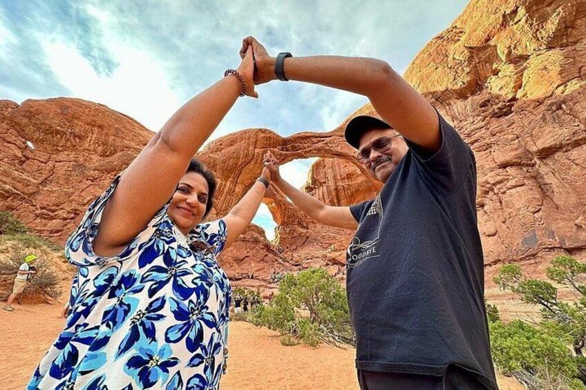 Two people in a desert landscape with red rock formations. 2