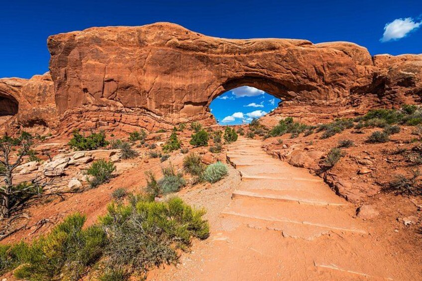 A red rock archway with a clear blue sky above. 5