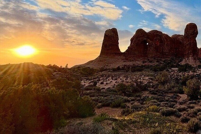 A desert landscape with rock formations and a sunset. 3