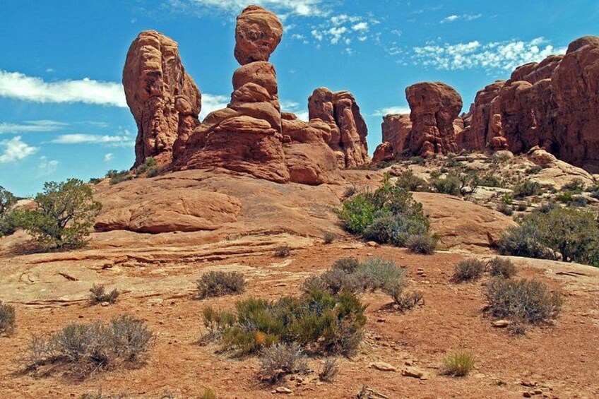 Paisaje desértico con formaciones rocosas rojas y vegetación escasa. 4