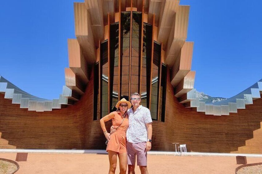 A modern building with a unique wooden facade and a staircase leading to the entrance. 1