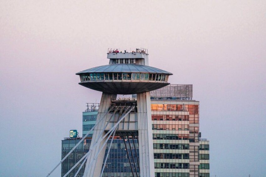 Una torre alta con un mirador de vidrio, rodeada de edificios modernos. 2