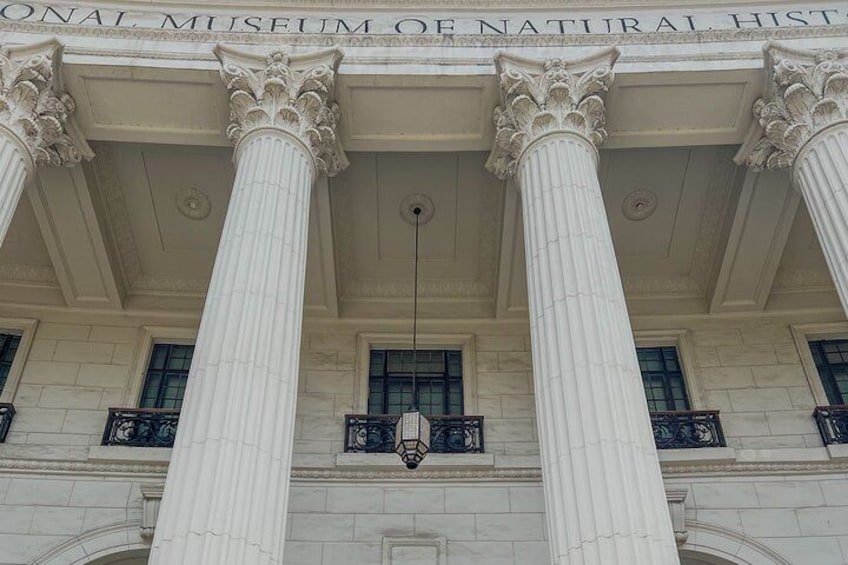 Un edificio con ampie colonne bianche e un cartello che riporta la scritta 'National Museum of Natural History'. 1