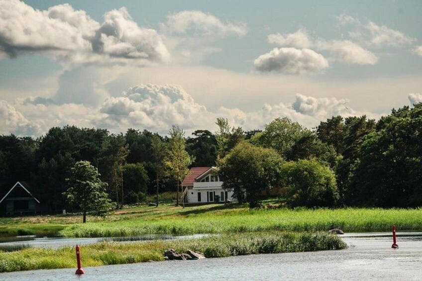 Een huis omgeven door weelderige begroeiing en een waterpartij. 3