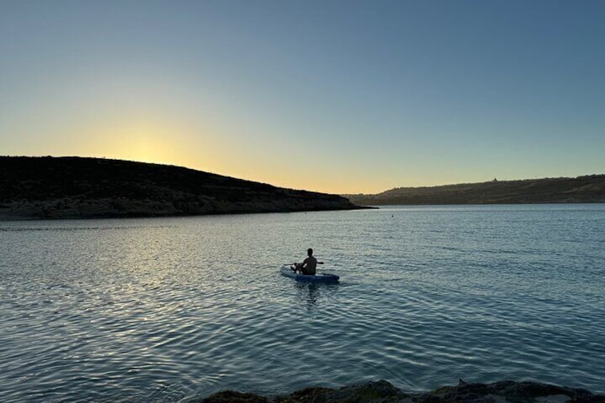 Una persona haciendo kayak en un lago tranquilo al atardecer. 5