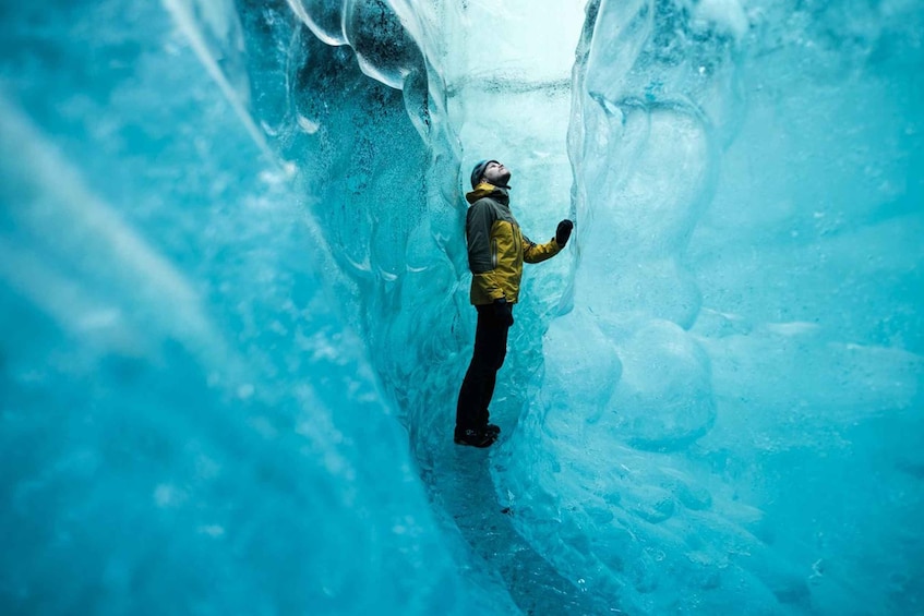 A person standing inside a large ice cave. 1