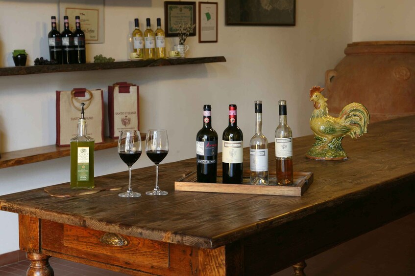 A wooden table with wine bottles and glasses. 1