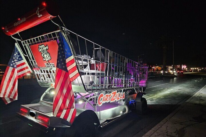 En väl upplyst food truck med texten ”Cart Zilla” på, amerikanska flaggor och ett rött och vitt randigt markis. 2