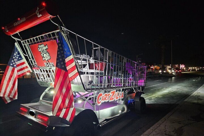 A food truck with 'Cart Zilla' branding, decorated with American flags, parked on a street at night. 2