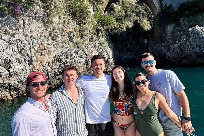 A group of people on a boat near rocky cliffs and water. 5