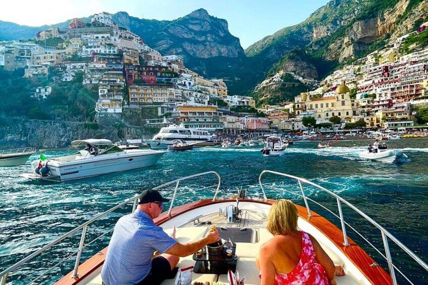 A boat on a calm sea with a coastal town in the background. 2