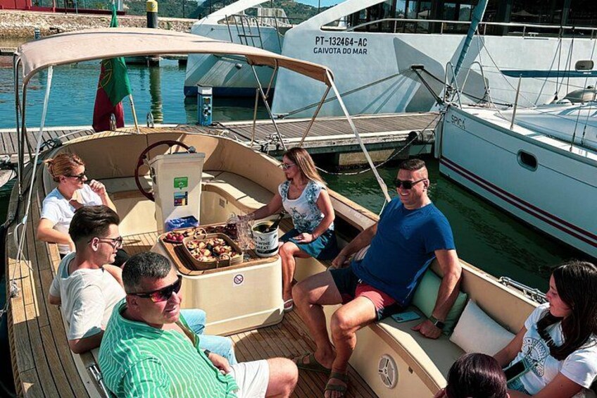 Un groupe de personnes se trouve sur un bateau doté d’un pont couvert, qui est amarré dans une marina, aux côtés d’autres bateaux. 3