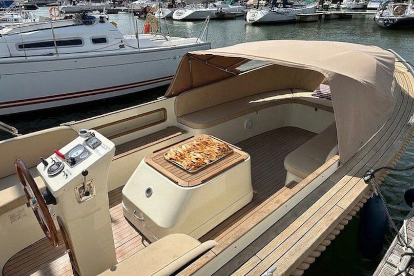Un bateau avec un pont en bois, une petite table garnie de nourriture et un panneau de commande. 2