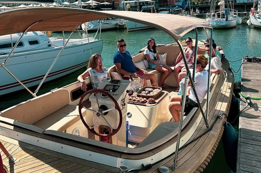 Un groupe de personnes se trouve sur un bateau dans une marina, avec d’autres bateaux amarrés à proximité. 5