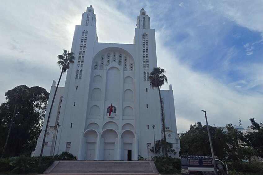 Une grande église blanche, dotée de deux tours et ornée d’une croix rouge sur sa façade. 2