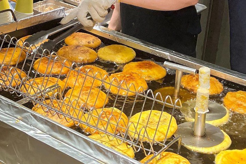 A deep fryer with several golden-brown fried items. 3
