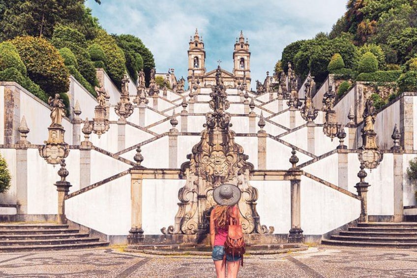 A grand staircase leading to a historic building with intricate architecture and statues. 1