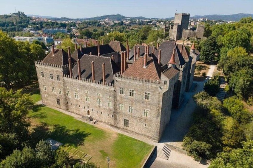 A large castle with multiple towers and a well-maintained lawn. 2