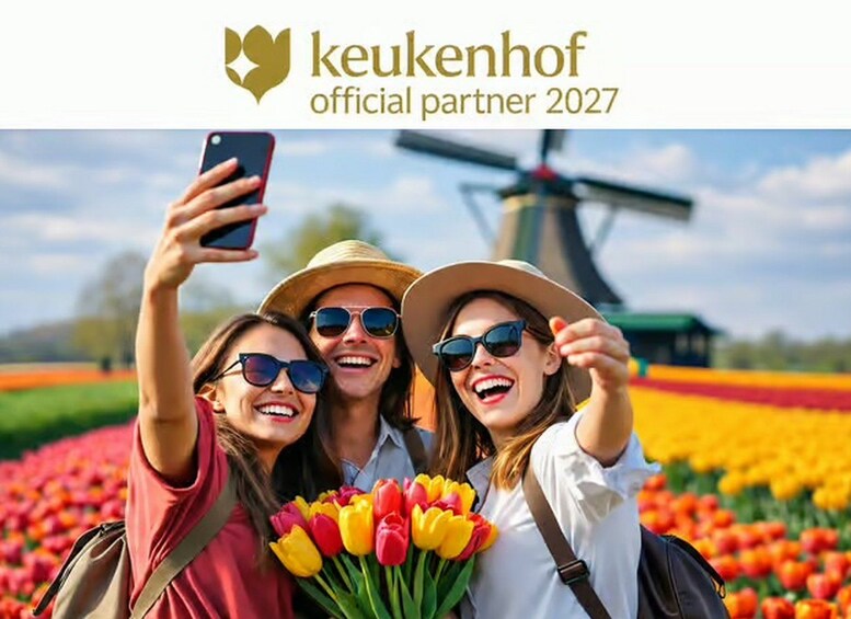 A group of people taking a selfie with a windmill and tulips in the background. 1