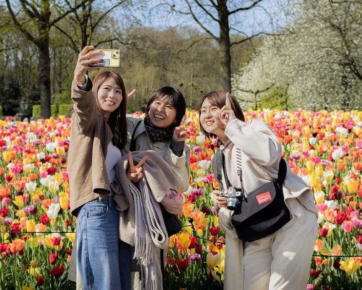 Three people taking a photo in a field of colorful tulips. 5