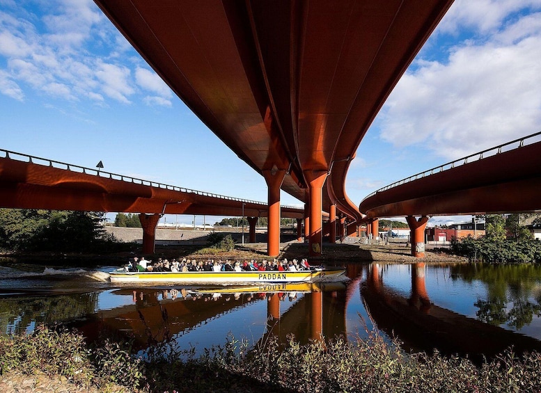 Een rivier onder een brug, met een boot vol passagiers. 5