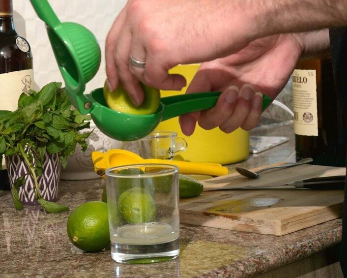 En person presser limesaft i et glas. 2