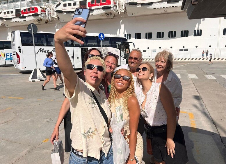 Ryhmä ihmisiä ottaa selfien risteilyaluksen edessä. 3