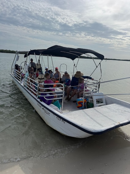 Un bote con pasajeros, una cubierta y agua tranquila. 2