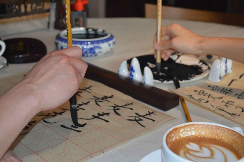 A person practicing calligraphy on a paper with a grid. 2