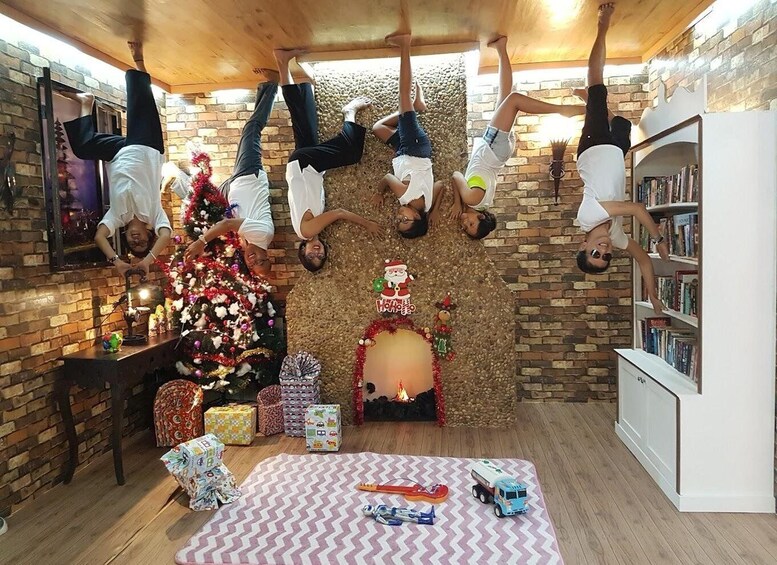 A room with a Christmas tree, presents, and a guitar on a rug. 5