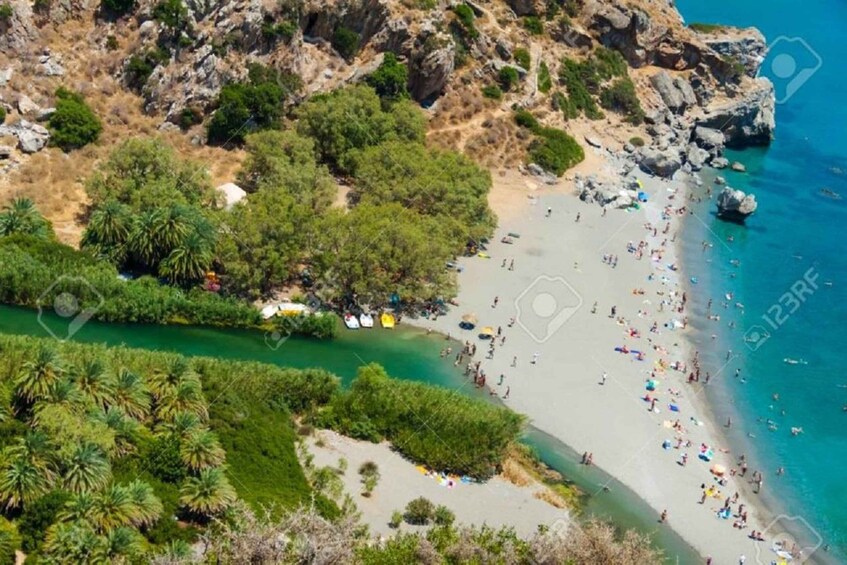 A coastal landscape with a beach, rocky cliffs, and dense greenery. 2