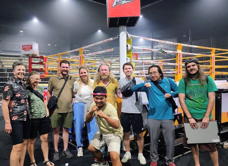 A group of people posing in a boxing ring with a 'BOOSTRONG' sign. 5