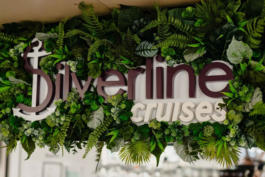 A sign for Silverline Cruises surrounded by lush greenery. 5