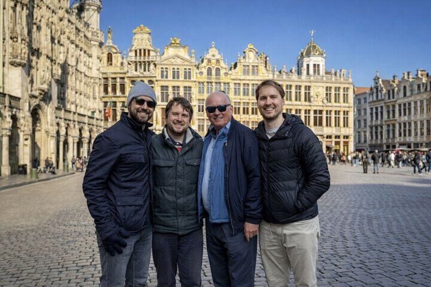 A group of people standing in front of a historic building with intricate architecture. 1